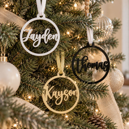 Custom family name Christmas tree ornaments in gold, white, and black, personalized holiday decorations for the whole family.