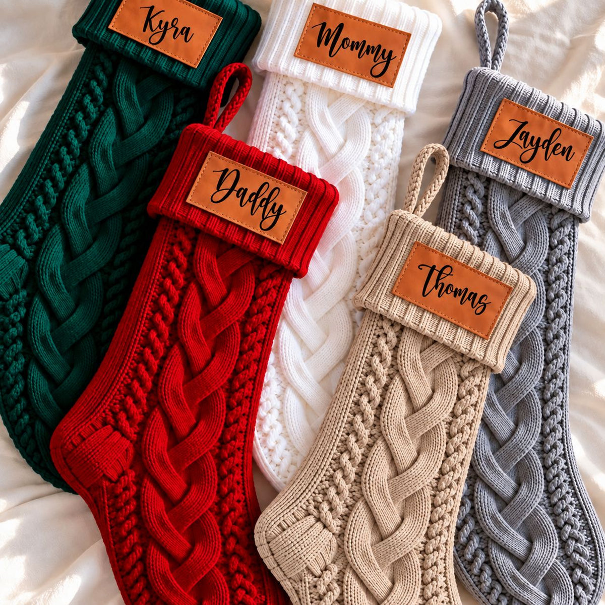 Custom name cable-knit Christmas stockings in matching family styles for personalized holiday gifting.