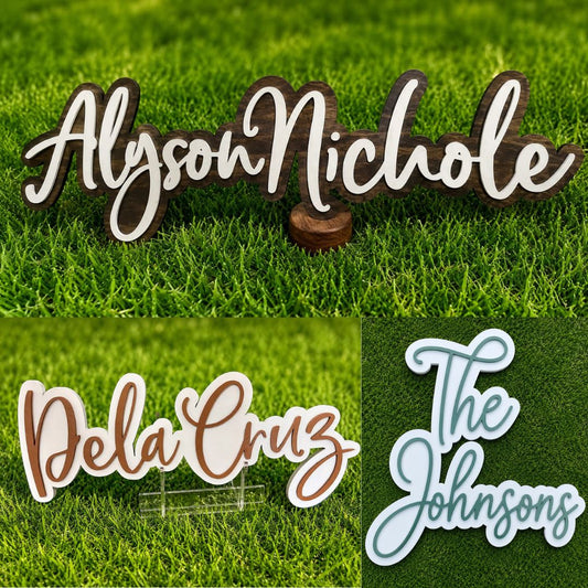 Collage of three custom laser-cut name signs displayed on vibrant artificial grass. The top features a dark wood and white layered "Alyson Nichole" sign, the bottom left shows a white and brown "Dela Cruz" sign on a clear acrylic stand, and the bottom right displays a white and sage green "The Johnsonsons" layered script sign. Clean white borders separate each product image in a square collage layout.