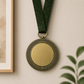 Gold medal with a braided antique bronze border and dark green neck ribbon.