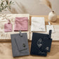 A collection of premium leather passport holders and matching luggage tag sets displayed flat on a white marble table in pink, white marble pattern, textured grey, and classic navy blue colors featuring custom laser engravings.