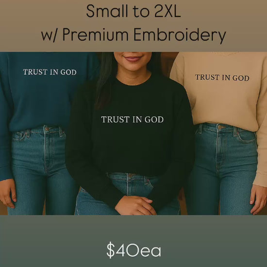 Video thumbnail highlighting premium 100% cotton crewneck sweaters with white custom text embroidery reading 'TRUST IN GOD', available in navy, black, and sand color options.